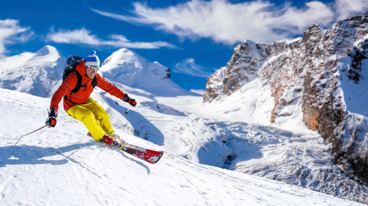Skier,Skiing,Downhill,In,High,Mountains,Against,Sunshine